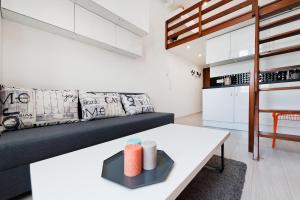 ein Wohnzimmer mit einem Sofa und einem Tisch in der Unterkunft Dietla 99 - Studio by Homeprime in Krakau