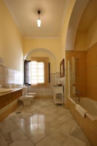 uma casa de banho com 2 lavatórios, um WC e uma banheira. em Posada de Palacio em Sanlúcar de Barrameda