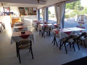 un comedor con mesas y sillas y una ventana en Hotel Shelter en Mar de Ajó