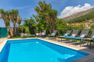 a swimming pool with chaise lounge chairs and a resort at Villa Hedera II in Dubrovnik