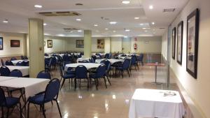 a dining room with tables and chairs in a room at Hotel Arcea Villaviciosa in Villaviciosa