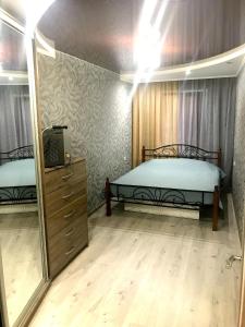 a bedroom with two beds and a tv and a mirror at Apartment on Pushkina (Prospect Soborniy) in Zaporozhye
