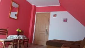 a room with a red wall with a door and a table at Pokoje Gościnne u Elżbiety in Sztutowo +35 photos