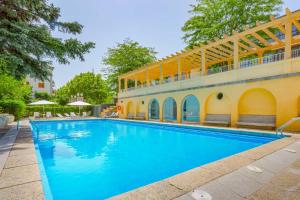 a swimming pool in front of a building at Exe Victoria Palace in San Lorenzo de El Escorial