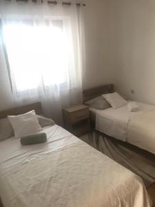 dwa łóżka w pokoju z oknem w obiekcie Apartman Iva w mieście Zadar