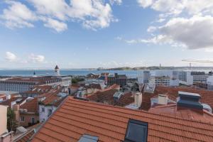 Blick auf eine Stadt mit roten Dächern in der Unterkunft LovelyStay - Stunning Penthouse with the best views in Lissabon