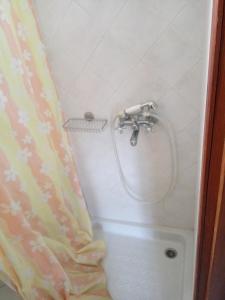 a shower with a hose in a bathroom at Castello Azzurro in Agia Anna Naxos