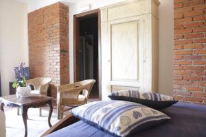 a bedroom with a bed and chairs and a brick wall at Casa Virgilio in Fosdinovo