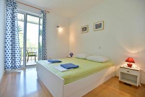 a white bedroom with a bed and a window at Apartments Mićić in Hvar