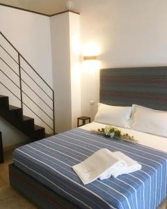 a bedroom with a bed with a blue and white striped blanket at B&B Salentus in Gallipoli