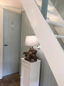 une lampe assise sur une armoire sous un escalier dans l'établissement Gite la Truite a Mouzaive, à Vresse-sur-Semois