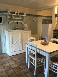 een keuken met een tafel en stoelen en een koelkast bij Gite la Truite a Mouzaive in Vresse-sur-Semois