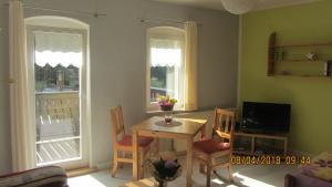 a dining room with a table and chairs and two windows at Fewo Jahn in Bad Schandau