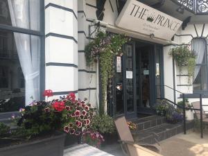 a building with flowers on the entrance to a store at The Prince Guest House in Great Yarmouth