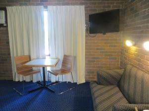 a living room with a table and chairs at Cattleman's Rest Motor Inn in Charters Towers