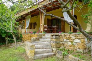 a stone staircase leading to a yellow house at Villa Umami in Makri