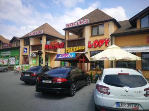 a group of cars parked in front of a building at Pensjonat Telimena in Zwierzyniec