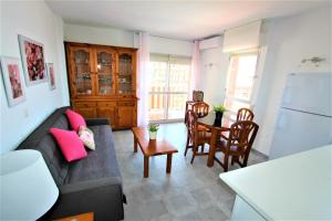 ein Wohnzimmer mit Sofa und Tisch in der Unterkunft 532 Minerva Apartamentos- Vistas al mar y a la piscina - Excelente Ubicación in Benalmádena + 24 Fotos