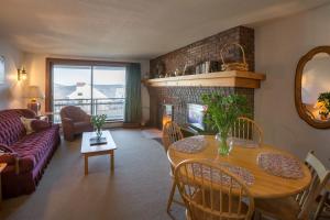 a living room with a table and a fireplace at Ski on ski off, beautiful views, 2 bedroom condo with access to indoor pool, Sunrise C5 in Killington