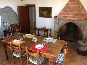 a dining room with a wooden table and a fireplace at Casa di Vittoria in Civitella in Val di Chiana