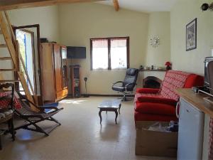 - un salon avec un canapé rouge et une chaise dans l'établissement Cottage provençal, à Belgentier