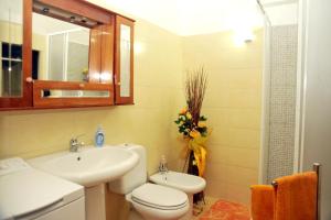 a bathroom with a sink and a toilet and a mirror at Bivano Villa Grazia in Fondachello +22 photos