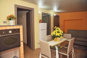 Bivano Villa Grazia في فونداشيلو: مطبخ وغرفة طعام مع طاولة وأريكة