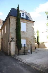 ceglany dom z drzewem przed nim w obiekcie Les Chambres d'Hotes chez Alisa et Daniel w mieście Sarlat-la-Canéda