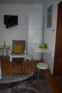 a room with a chair and a table and two stools at Guest House Ozon in Soko Banja