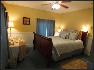 - une chambre avec un lit et un ventilateur de plafond dans l'établissement Sunnyside Inn Bed &Breakfast, à Sunnyside