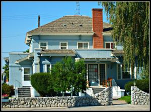 une maison bleue avec une clôture en pierre devant elle dans l'établissement Sunnyside Inn Bed &Breakfast, à Sunnyside