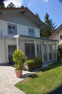 una casa blanca con porche y algunas plantas en Ferienwohnung Irmgard, en Hauzenberg