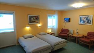 una habitación de hotel con 2 camas y una silla en Bollegården B&B en Bollnäs