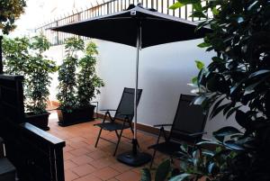 een patio met 2 stoelen en een parasol bij Morris Bed & Breakfast in Bari