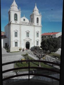 フィゲイラ・ダ・フォズにあるLargo da Igrejaの時計塔のある白い大きな建物