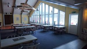 a dining room with tables and chairs and windows at Bollegården B&B in Bollnäs