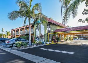 um hotel com palmeiras em frente a um parque de estacionamento em Vagabond Inn Costa Mesa em Costa Mesa