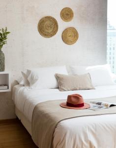 Un dormitorio con una cama con un sombrero encima. en Zip Housing El Golf, en Santiago