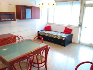 a room with a table and chairs and a couch at Condominio VILLA CHIARA in Lignano Sabbiadoro