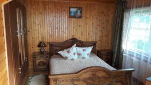 a bedroom with a wooden bed with pillows on it at U Romana in Yaremche