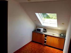 a kitchen with a sink and a window on the ceiling at Vila di Pau in Băile Herculane
