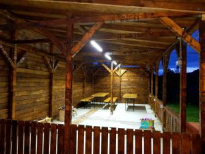 an inside of a wooden cabin with tables and benches at Vila di Pau in Băile Herculane