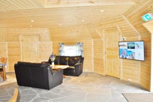 a living room with two leather chairs and a table at Cape Marina Lodge in Skarsvåg