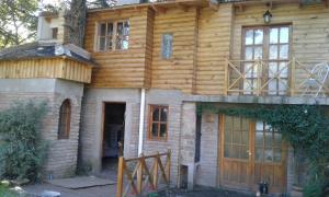 a house being built with wooden walls and doors at Cabañas Ailen in Sierra de la Ventana