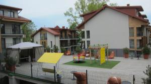 um parque infantil num pátio de um edifício de apartamentos em 2 kambarių apartamentai em Palanga