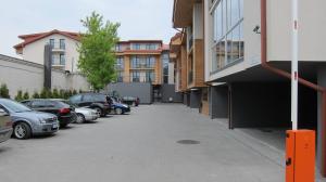 um parque de estacionamento com carros estacionados ao lado de edifícios em 2 kambarių apartamentai em Palanga