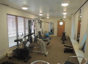 a gym with several tread machines in a room at Apartment with Swimming Pool in Tenby