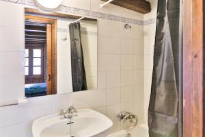 y baño con lavabo y espejo. en Hostal Cisco de Sans, en Andorra la Vella