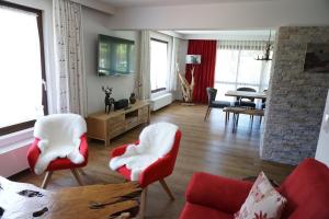 - un salon avec des fauteuils rouges et blancs et un canapé dans l'établissement Ferienhaus Alpenperle, à Grainau