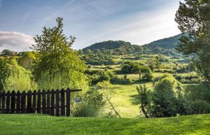 a fence in the grass with a view of a field at Casa Rural El Serrano in Prioro